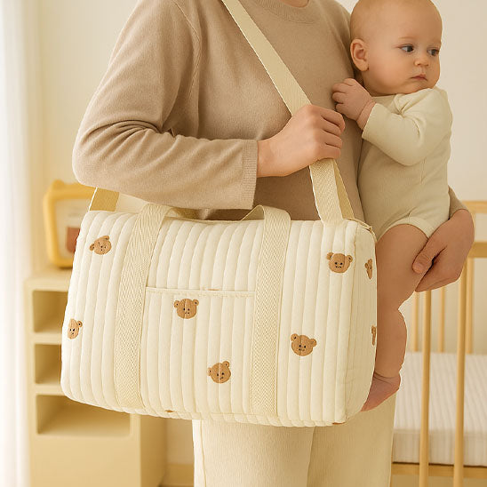 Bébé dans bras de maman avec sac a langer